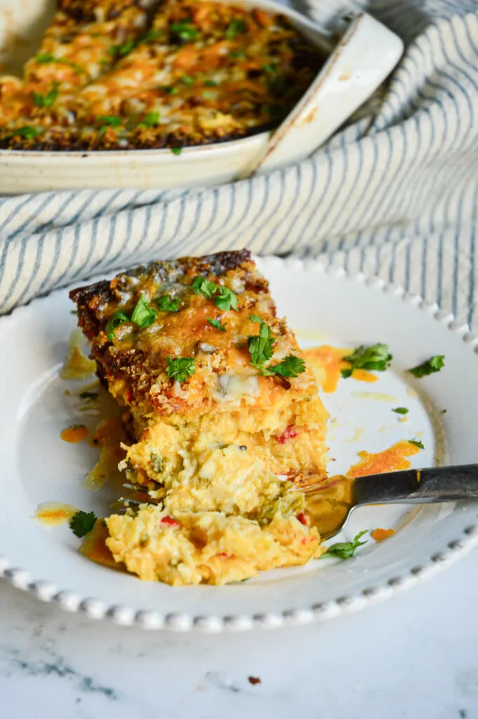 slice of spaghetti squash casserole on white plate with casserole in background