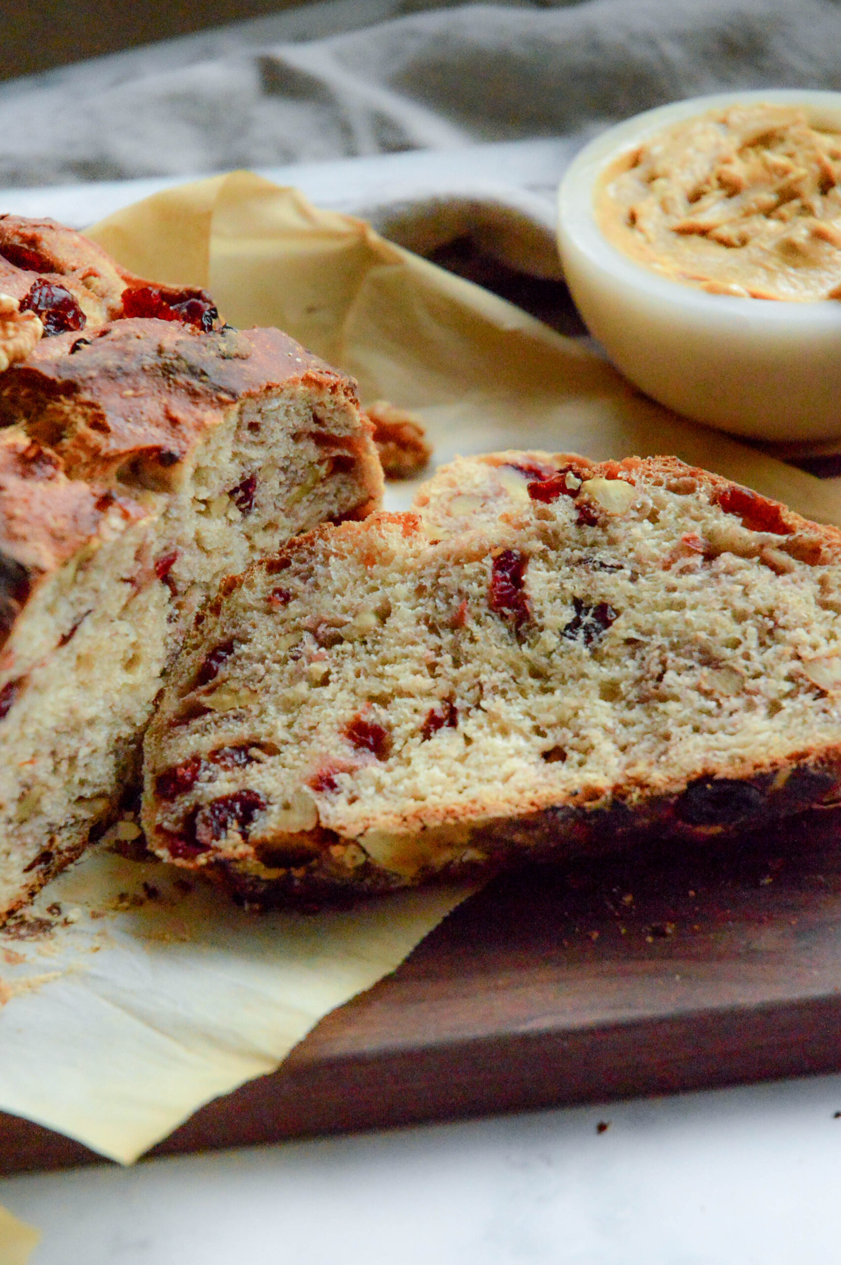cranberry walnut bread recipe on bread board with molasses butter