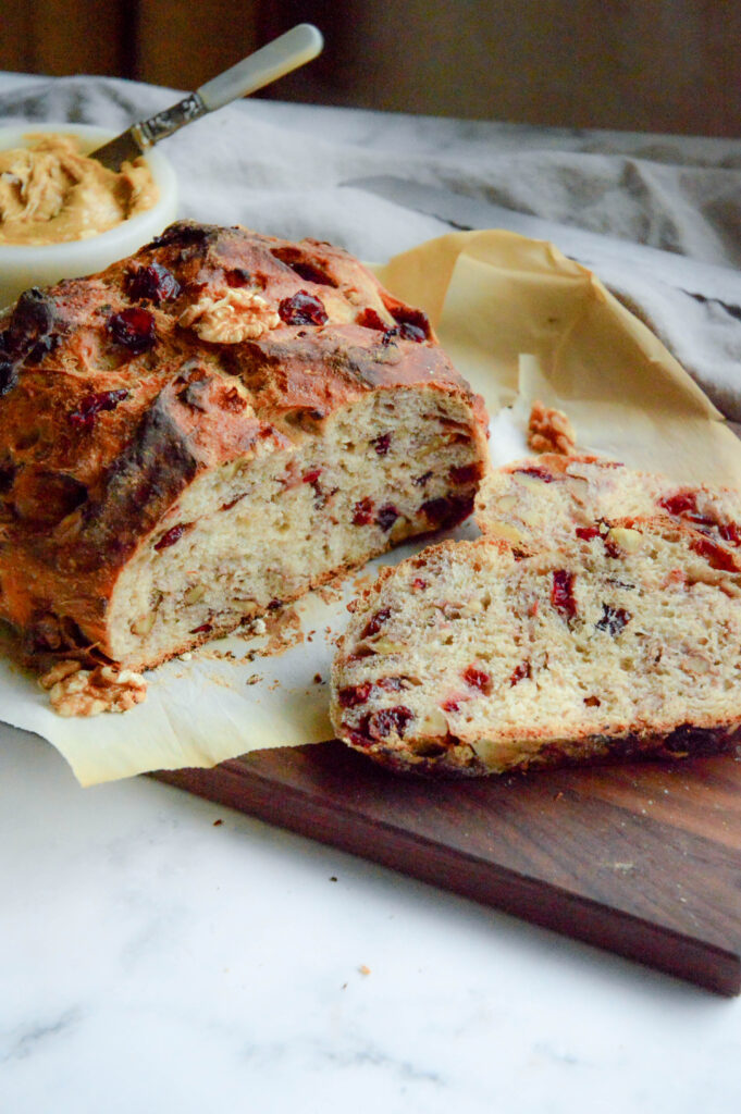 cranberry walnut bread recipe on cutting board with molasses butter
