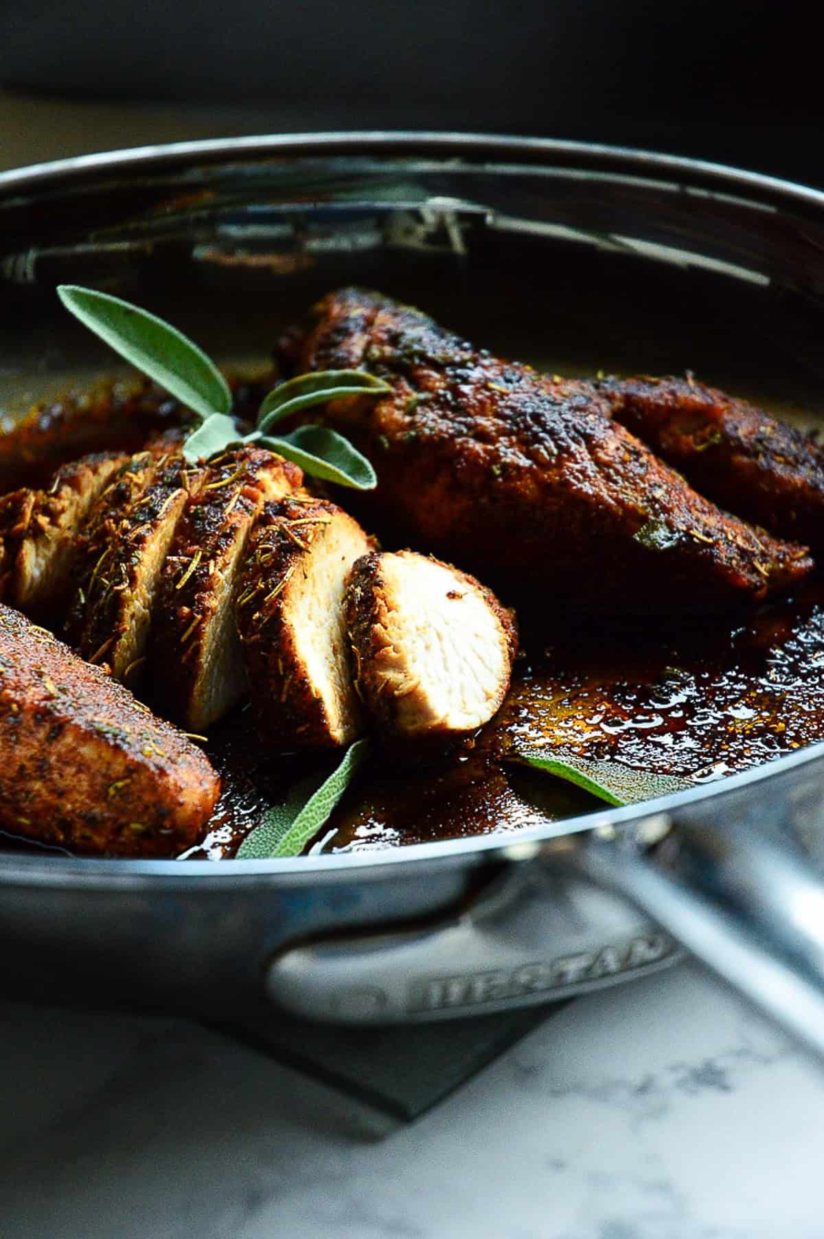 sliced turkey tenderloin in skillet with unsliced turkey tenderloin