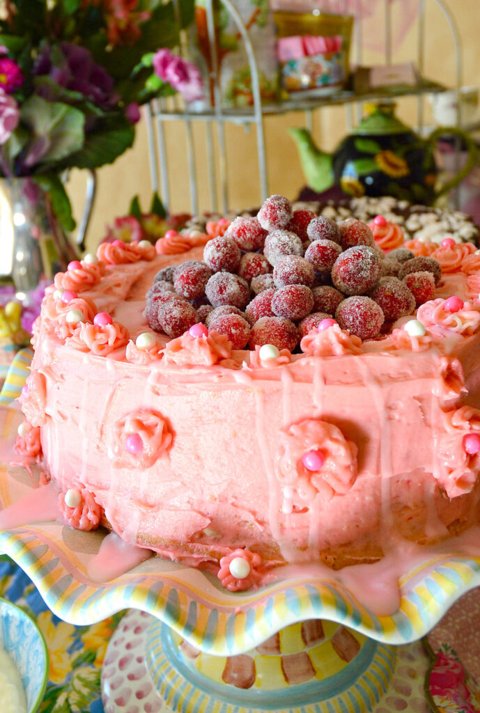 Pink Dyed White Chocolate Icing for White Cake with Cranberries on cake platter