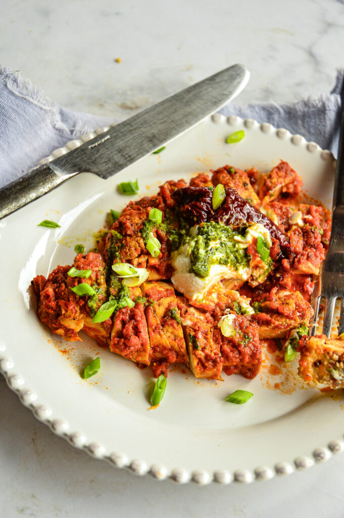 chipotle red sauce recipe over chicken on white plate with knife