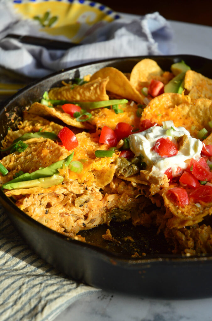 green chile chicken casserole recipe in cast-iron skillet with wedge slice
