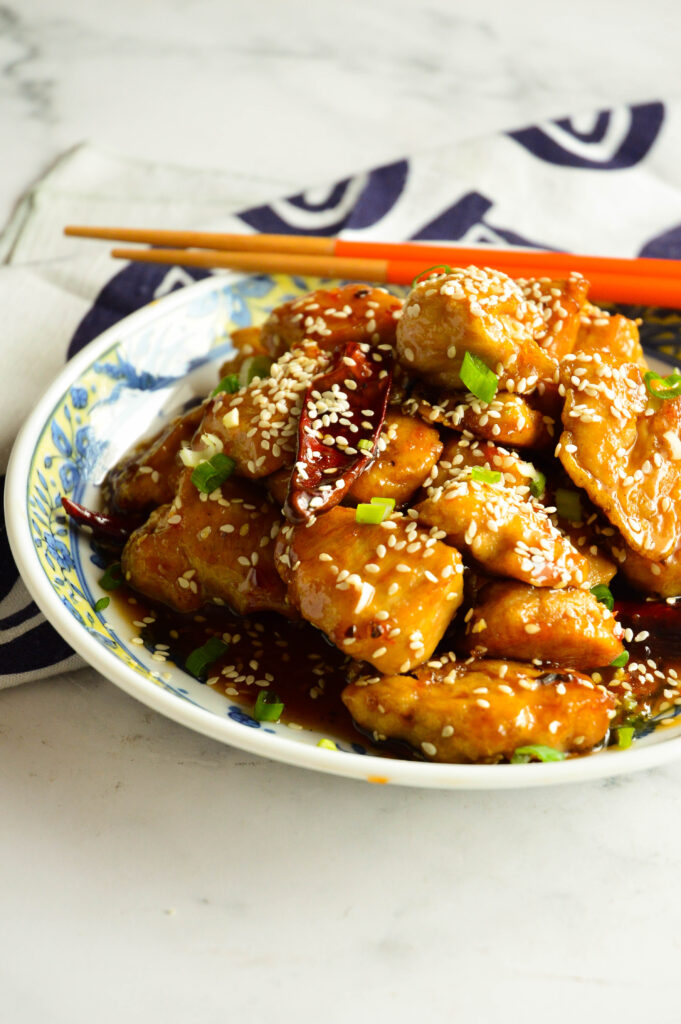 Chinese sweet and spicy chicken recipe in Asian bowl with chopsticks