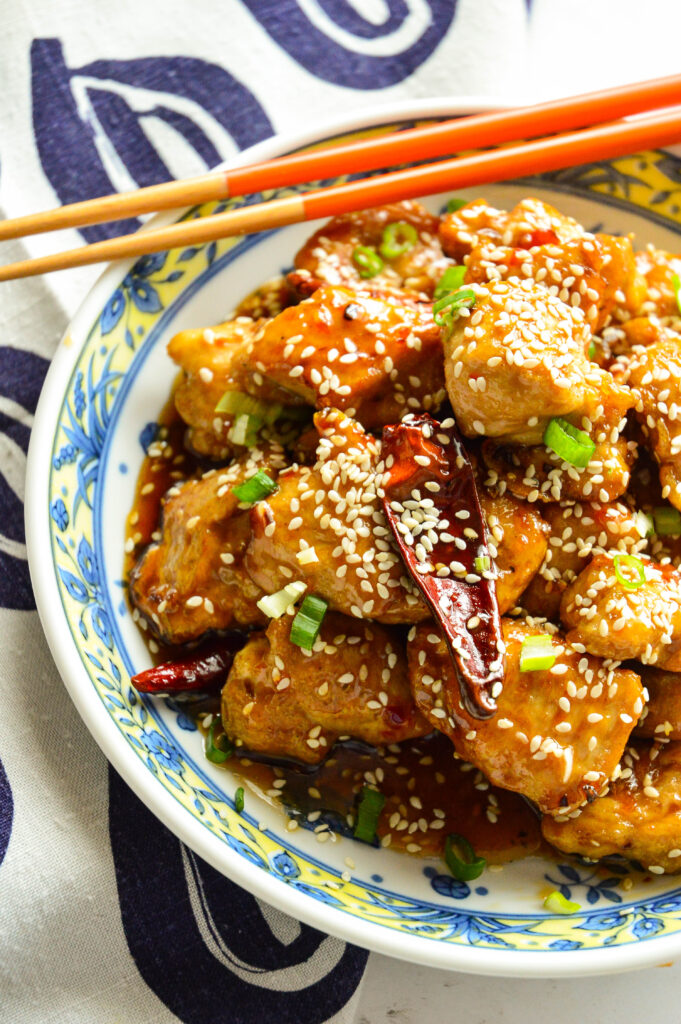 Chinese Sweet and Spicy Chicken Recipe (Sesame Chicken in Asian bowl with chopsticks)