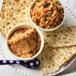 Charoset in white bowl with blue and white spoon and matzo on white plate