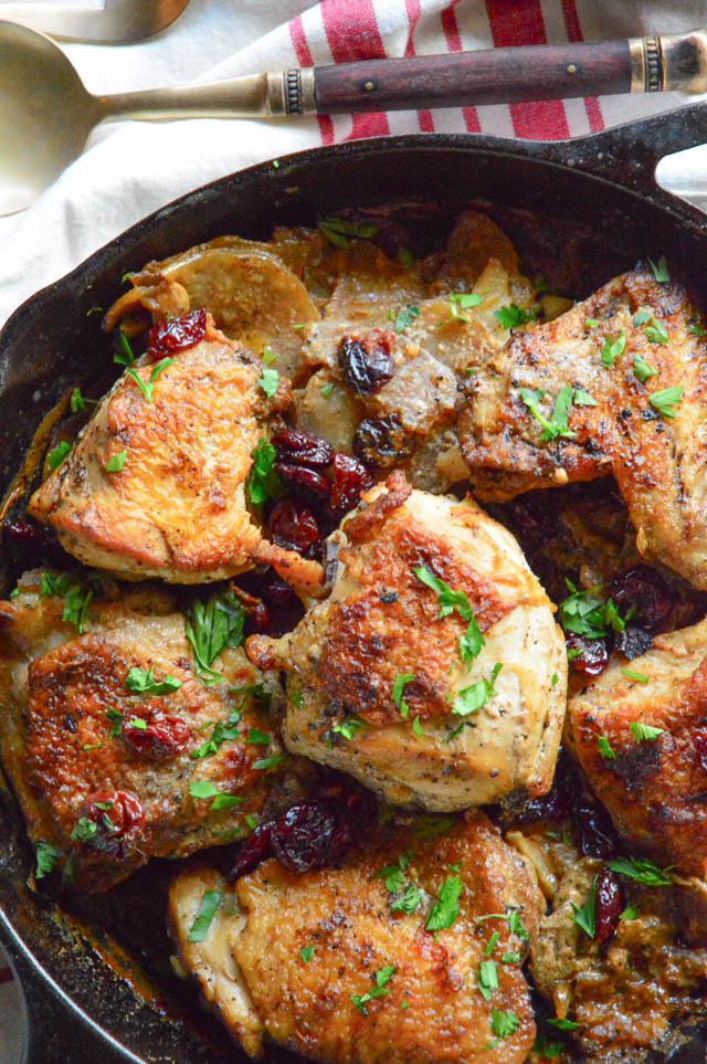 garlic braised chicken with cherries and potatoes and mushroom in skillet