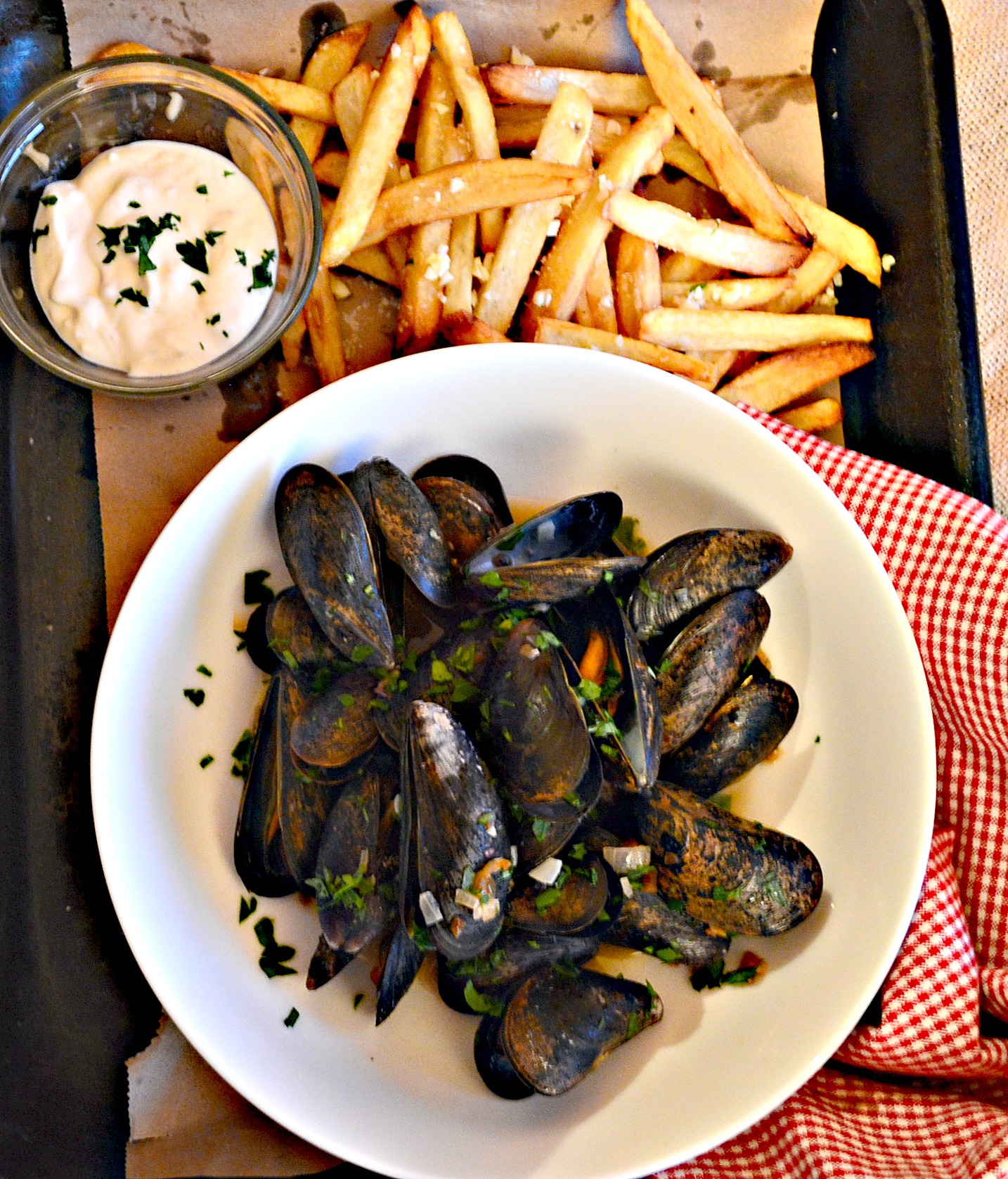 mussels in white wine sauce in white bowl with homemade french fries