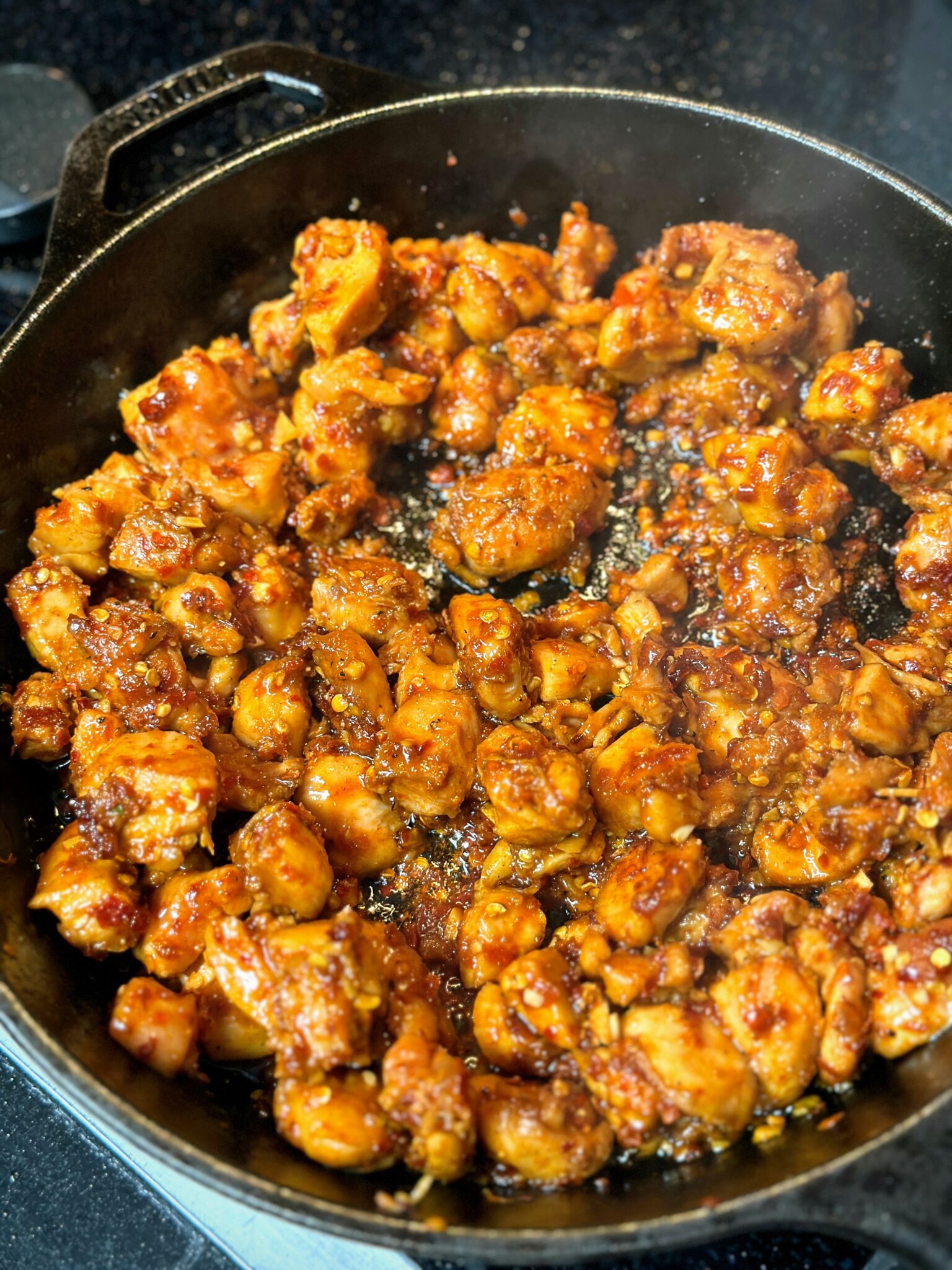 fire chicken cooking in cast iron skillet