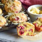 cranberry orange muffins in muffin pan with butter