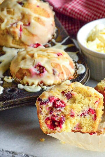 cranberry orange muffins in muffin pan with butter
