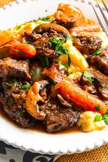 boeuf bourguignon white plate with fork