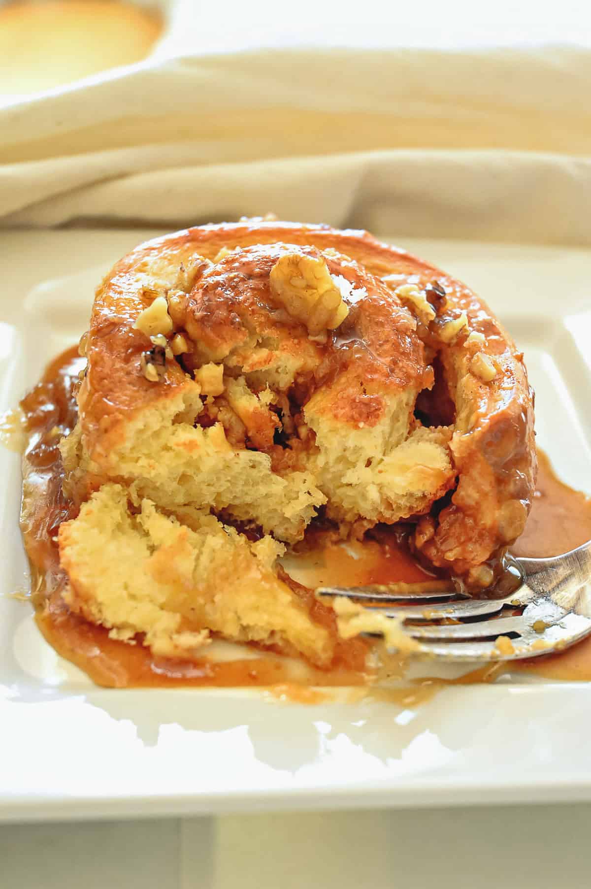 sticky bun with fork and one bite on fork