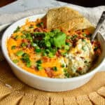 jalapeno popper dip recipe in white baking dish on burlap place mat