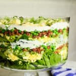 layered salad recipe in clear glass trifle bowl