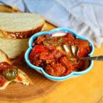 tomato matbucha recipe in decorative blue rimmed bowl with silver spoon