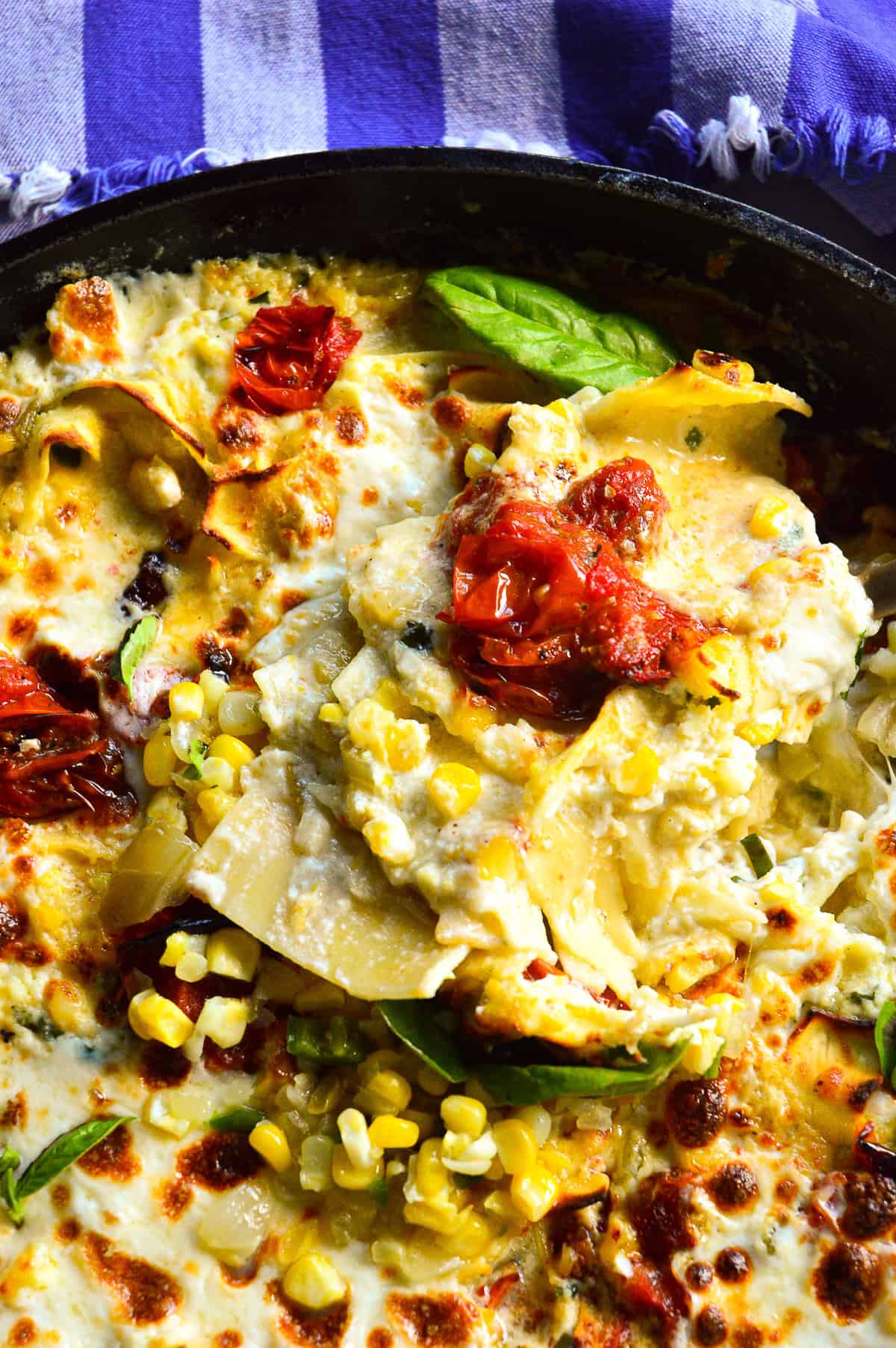 reccipe for skillet lasagna in cast iron skillet with corn and roasted tomatoes