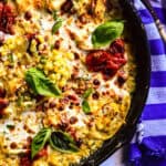 corn lasagna in a skillet with blue striped napkin