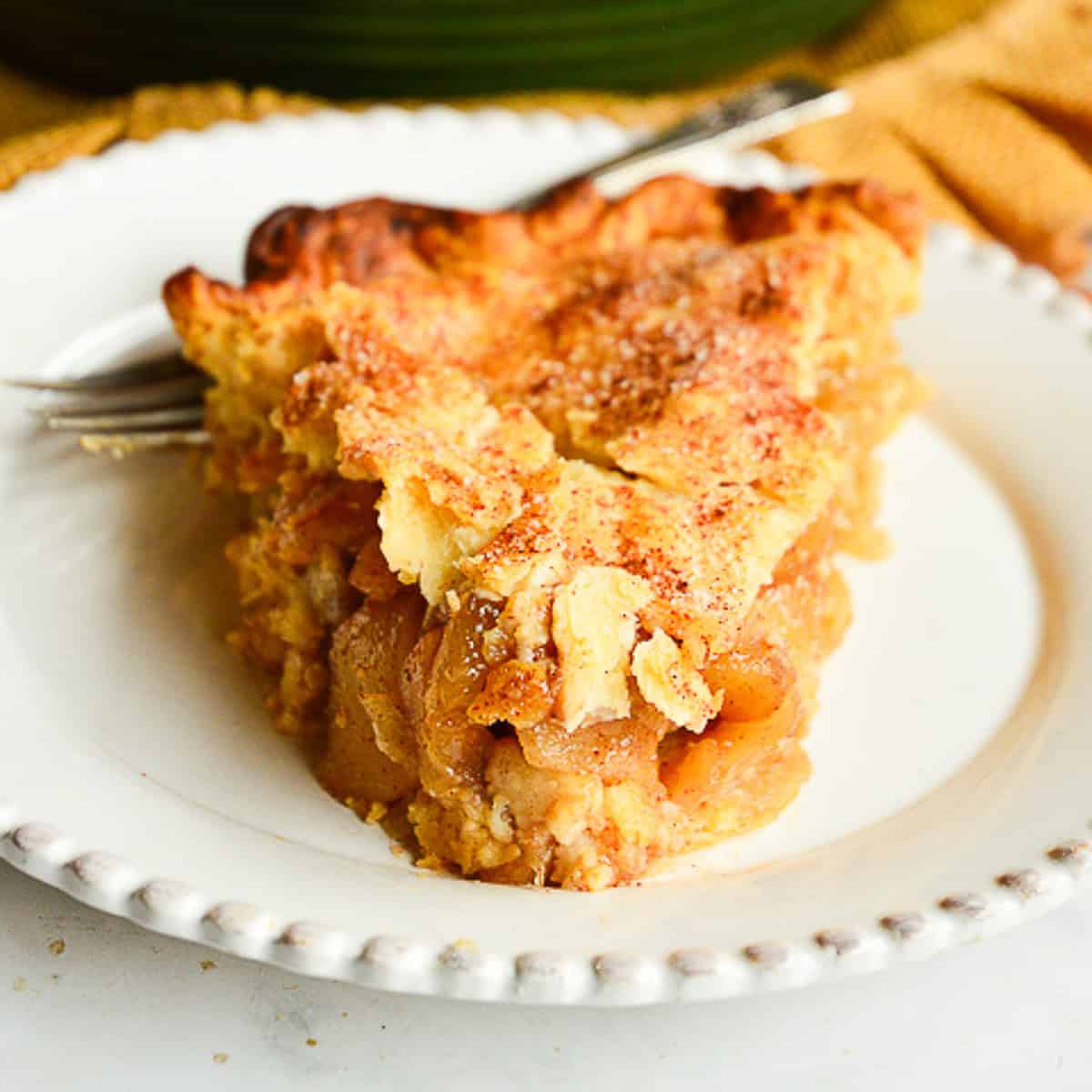 slice of apple pie on white plate with fork
