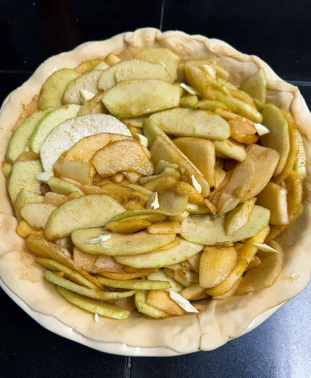 apple pie before baking dotted with butter
