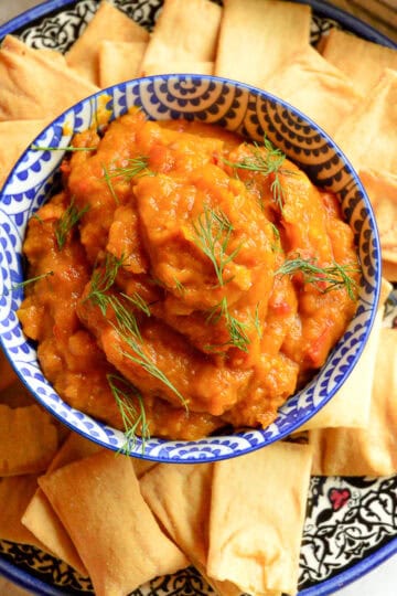 pumpkin dip recipe in blue and white bowl on platter with pita chips