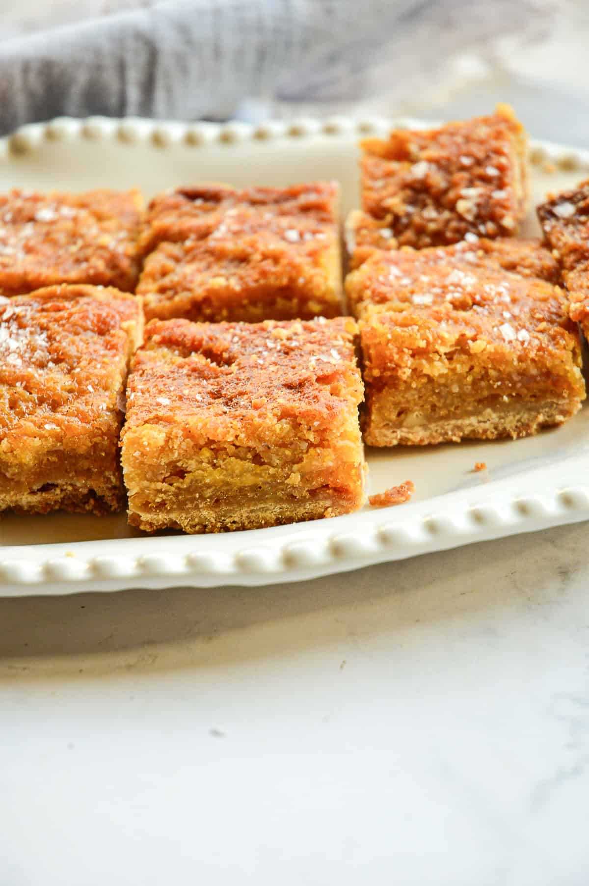 squares of salted honey bars on white ceramic tray