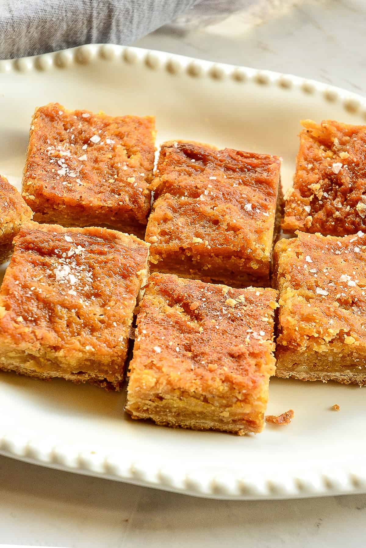 salted honey bars recipe with brown butter cut into squares on white serving plate