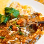 colorado pork green chili on plate with spoon and rice in background