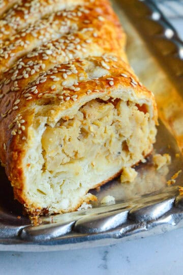 potato knish in strudel form on silver platter
