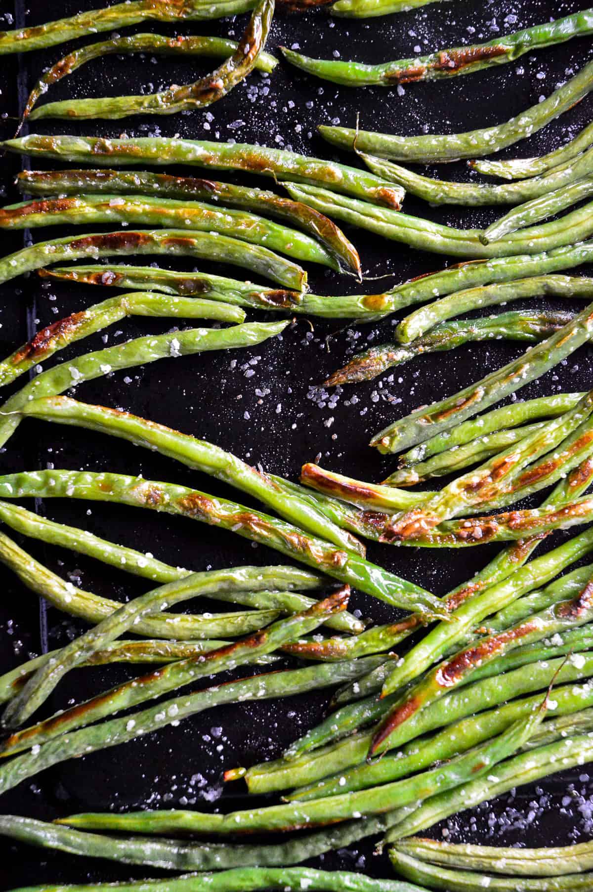oven roasted green beans with salt on black pan