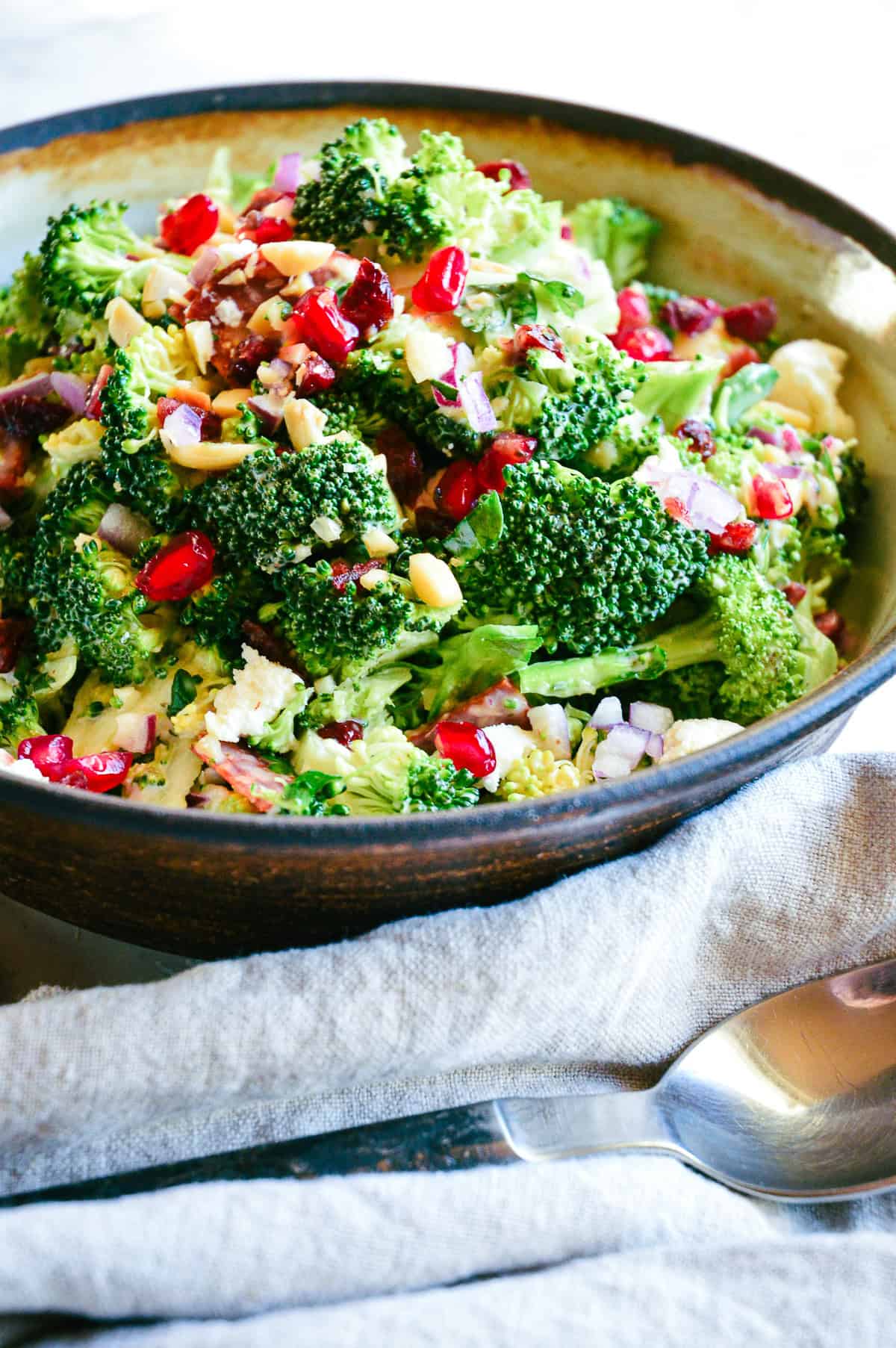 fall salad in earthenware dish with broccoli and pomegranate seeds