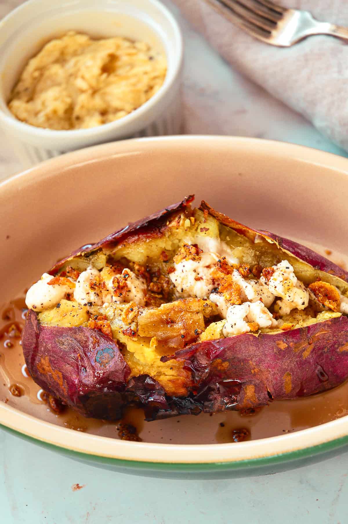 sweet potato with maple black pepper butter and cinnamon syrup in green baking dish