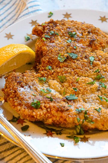 chicken schnitzel on gold starred plate with silver fork