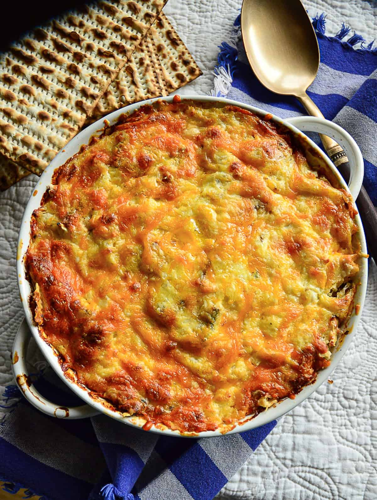 Passover mac and cheese made with matzo in round white baking dish