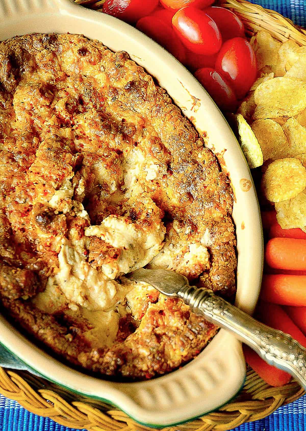 warm onion dip with pepper served with veggies and chips
