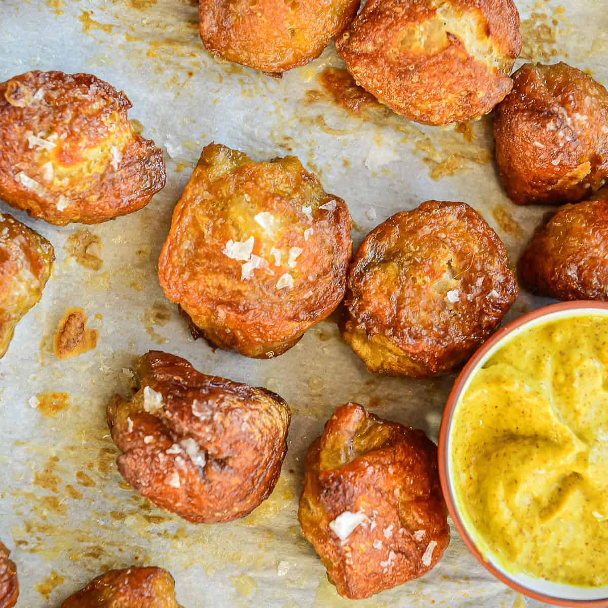 Soft Pretzel Bites made from pizza dough on baking sheet with mustard