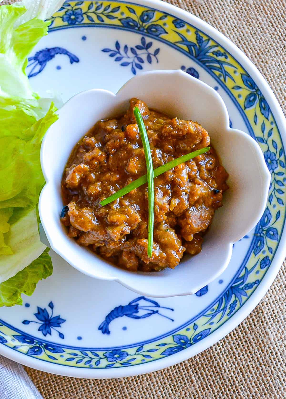 Thai peanut pork dip in white lotis bowl on an Asian plate