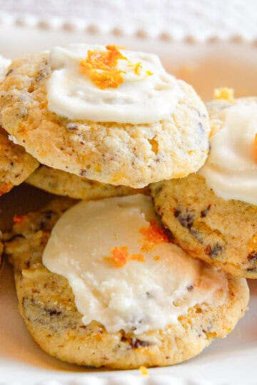 orange cookies with frosting on white plate