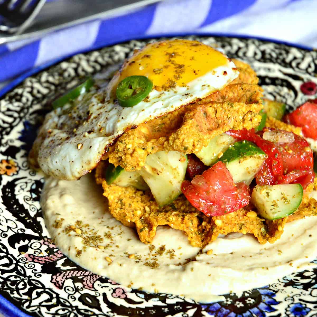 falafel waffle with Israeli salad and fried egg on hummus
