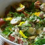dill pickle herby potato salad with peepperoncini in white bowl