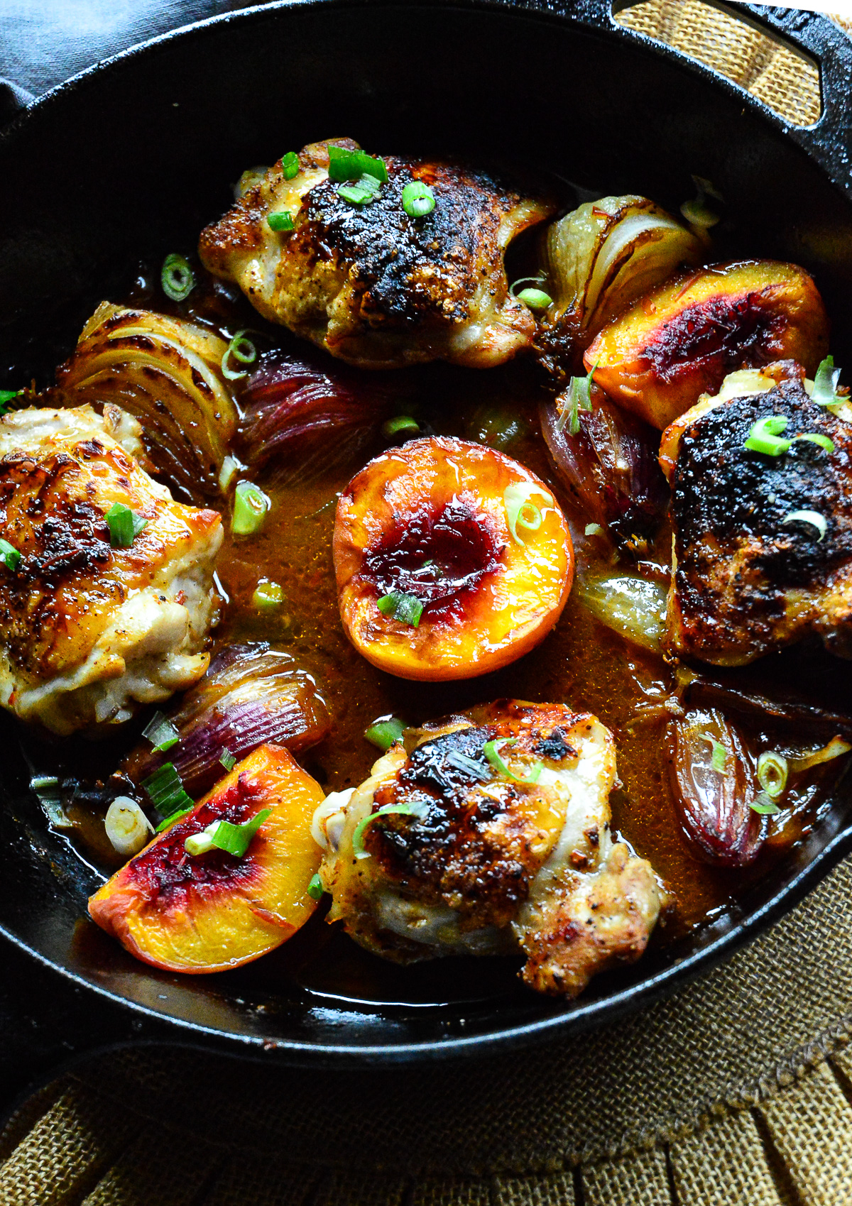 harissa honey chicken recipe in cast iron skillet with peaches