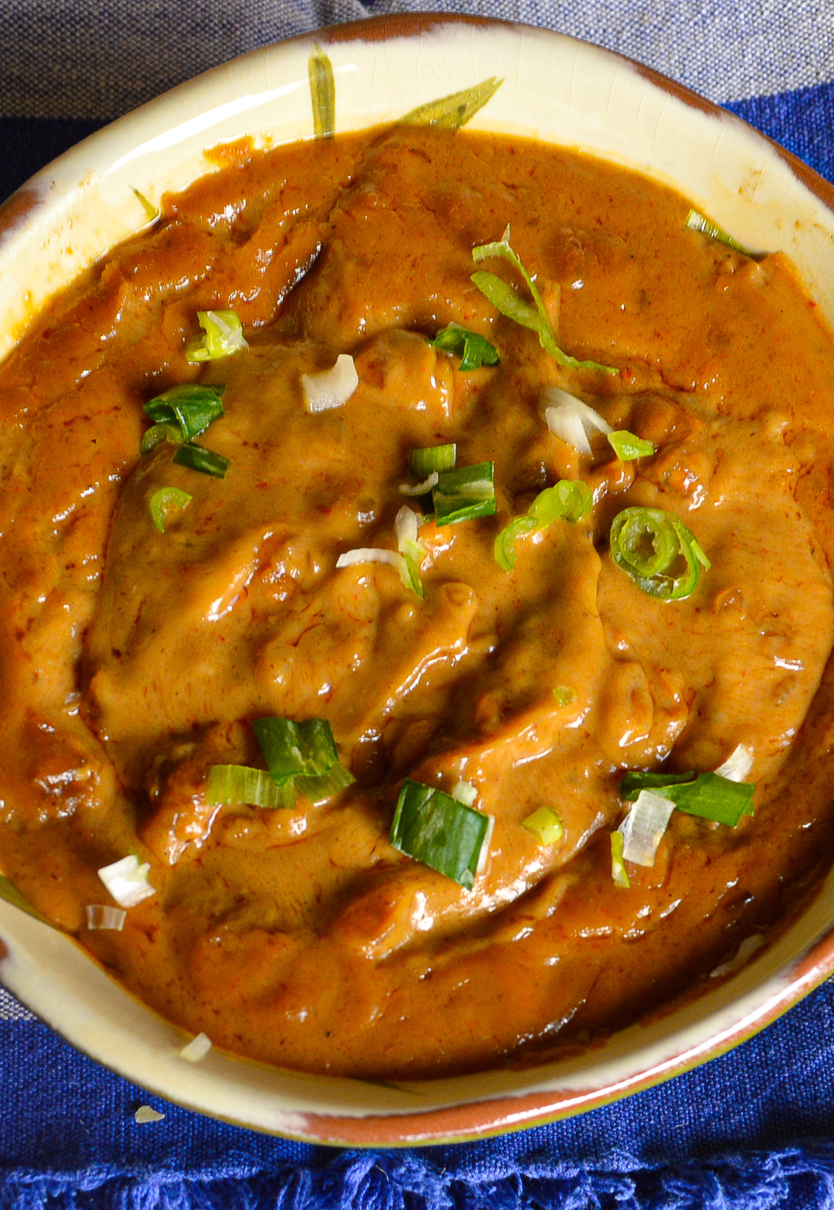 homemade peanut sauce in bowl with scallion garnish