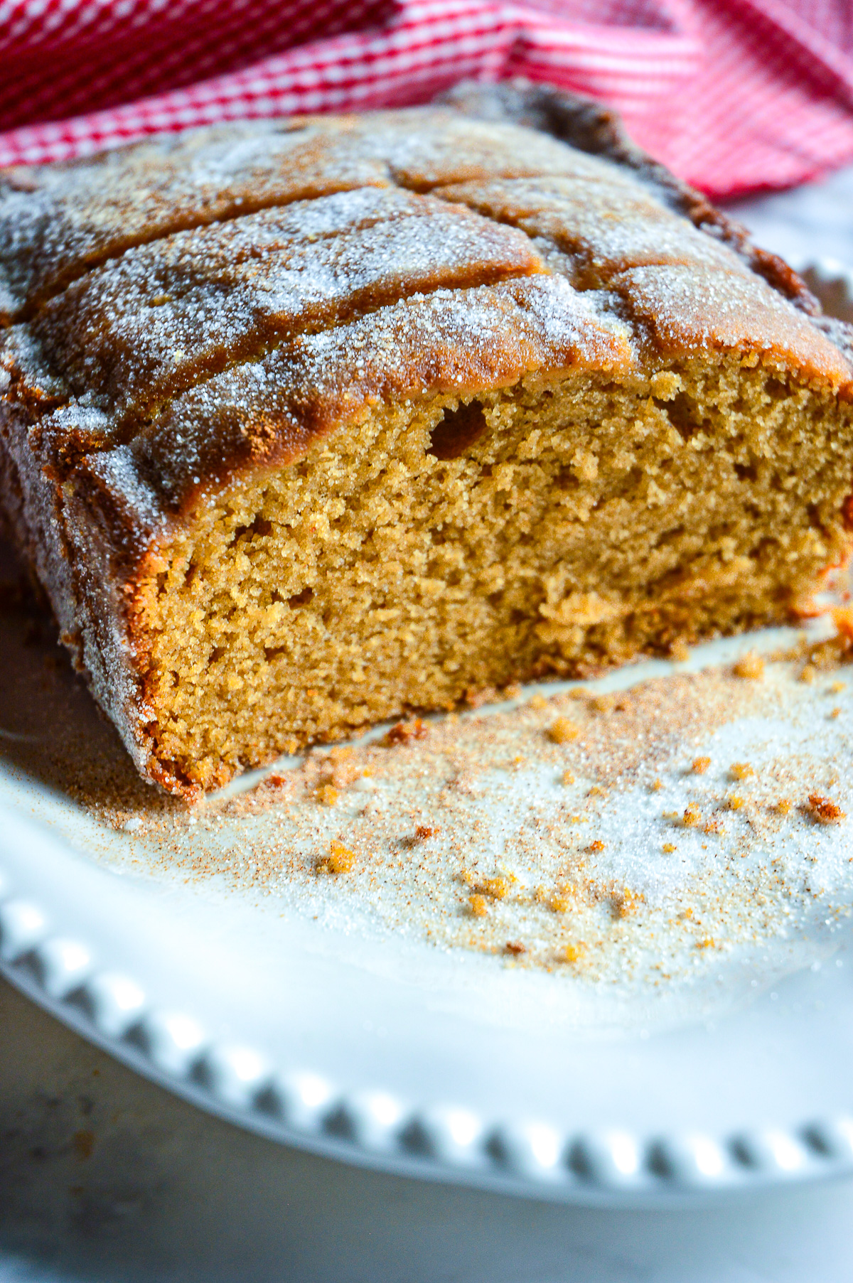 apple loaf cake with  coder on white plate with red checked napkin