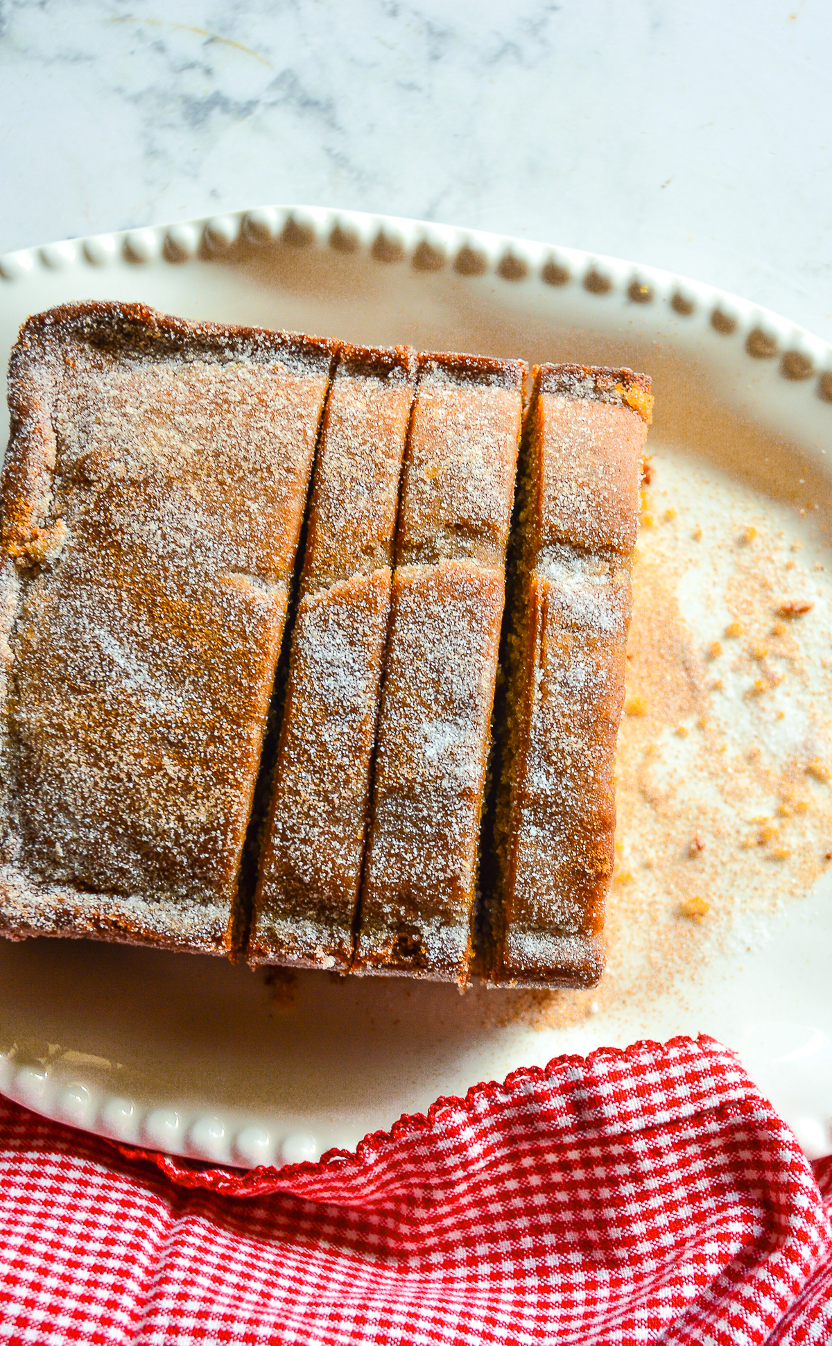 apple cider cake on white beade plate, sliced from a loaf