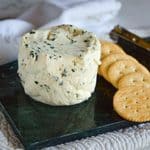 Homemade garlic and herb Boursin-style cheese spread with chives and parsley served with crackers