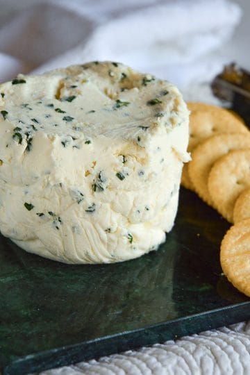 Homemade garlic and herb Boursin-style cheese spread with chives and parsley served with crackers